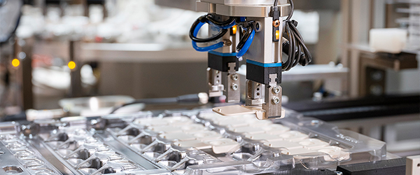 Robotic grippers picking up filter housing
